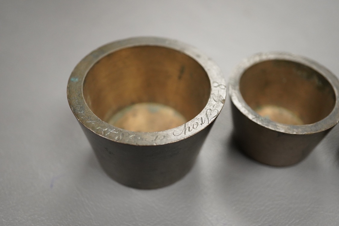 Two sets of bronze Troy nesting weights, one incomplete, with engraved rims, largest 8oz
